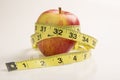 Weight loss solution concept. Red apple with measure tape. Royalty Free Stock Photo