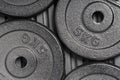 Weight plates on a black rubber floor inside a weight training gym