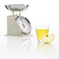 Weight scale with apple juice glass isolated on white background Royalty Free Stock Photo