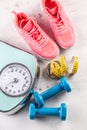 Weight scale, trainers and dumbbells with measure tape on floor. Sports and workout equipment on a floor Royalty Free Stock Photo