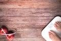 Weight scale white digital with women feet standing on scale and diet red apple bind with measuring tape on the wooden backgrounds