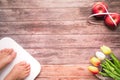 Weight scale white digital with women feet standing on scale and diet red apple bind with measuring tape on the wooden backgrounds Royalty Free Stock Photo