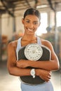 Weight to go on your diet goals. Portrait of a fit young woman holding a scale in a gym. Royalty Free Stock Photo