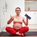 Weight training during pregnancy. A pregnant woman lifts dumbbells with both hands