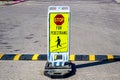 Weighted stand-up Stop for Pedestrians sign in grainy concrete parking lot by striped speed bump copy Royalty Free Stock Photo
