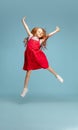 Happy redhair girl isolated on blue studio background. Looks happy, cheerful, sincere. Copyspace. Childhood, education