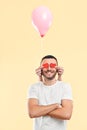 Weird funny man with small paper hearts by their eyes and pink air balloon on his neck