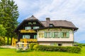 WEISSENSEE LAKE, AUSTRIA - JUL 6, 2015: Typical alpine guest house on green meadow in summer landscape of Weissensee lake, Austria