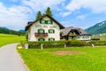 WEISSENSEE LAKE, AUSTRIA - JUL 6, 2015: Typical alpine guest houses on green meadow in summer landscape of Weissensee lake,