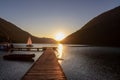 Weissensee - Wooden pier at the east shore of alpine lake Weissensee at sunset. Small sailinng boat