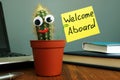 Welcome aboard concept. Funny cactus on workplace in the office Royalty Free Stock Photo