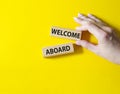 Welcome aboard symbol. Concept word Welcome aboard on wooden blocks. Beautiful yellow background. Businessman hand. Business and Royalty Free Stock Photo