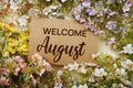 Welcome August text message with flower decoration on yellow background