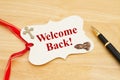 Welcome Back message gift tag with yellow ribbon praying hands, cross and pen Royalty Free Stock Photo