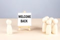 WELCOME BACK text on easel with wooden figure, meeting concept Royalty Free Stock Photo