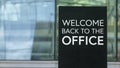 Welcome back to the office on a sign outside a modern glass office building Royalty Free Stock Photo