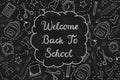 Welcome back to school with doodles on a black chalkboard. Textured background.