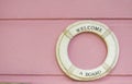 Welcome a board white life belt on pink wooden background Royalty Free Stock Photo