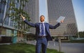 Welcome business. Happy leader standing in front of company building make winner gesture. Royalty Free Stock Photo