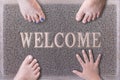 Welcome Door Mat With Three Feet and One Hand. Royalty Free Stock Photo