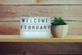 Welcome February word in light box on wooden shelves background Royalty Free Stock Photo