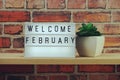 Welcome February word in light box on wooden shelves background Royalty Free Stock Photo