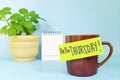 Welcome, hello and happy Thursday concept. Selective focus of coffee cup with green paper note.