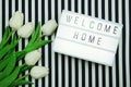 Welcome Home Light box letters Flat Lay with tulip flower bouquet