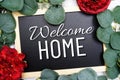 Welcome Home text on blackboard and eucalyptus leaves decoration on marble background