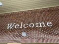 Welcome letters spelled on a brick wall white letters