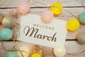 Welcome March card typography text with LED cotton ball on wooden background Royalty Free Stock Photo