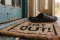 Welcome mat in front of a door saying Stay out Royalty Free Stock Photo