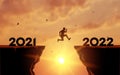 Welcome Merry Christmas in 2022. A young man jump between 2021 and 2022 years over the sun and through on the gap of hill Royalty Free Stock Photo
