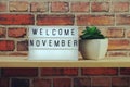 Welcome November word in light box on wooden shelves background Royalty Free Stock Photo