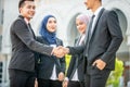 Welcome onboard! Muslim Asian business people shaking hands with new partner, business co-working teamwork concept Royalty Free Stock Photo