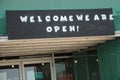 tor, canada - july 31, 2023: welcome we are open sign above store doors on canopy construction, green black. phot