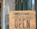 Welcome, we are open sign on the door of the store/cafe. Wooden board with text. Business after quarantine concept. Royalty Free Stock Photo