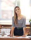 Welcome. Please have a seat. Cropped portrait of a young businesswoman standing behind her desk in the office. Royalty Free Stock Photo
