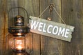 Welcome sign with iron key hanging next to antique lantern