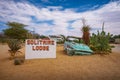 Welcome sign at the Solitaire Lodge with a car wreck in the namibian desert Royalty Free Stock Photo