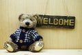 Welcome Sign and Teddy bear on wooden background Royalty Free Stock Photo