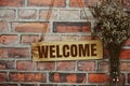Welcome sign text message on wooden board hanging on old brick wall background Royalty Free Stock Photo