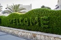 Welcome sign to the hotel of Reef Oasis Beach Resort 5 cut on the green bush