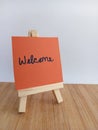 Welcome sign on a wood easel on a wood background