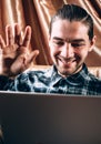 Welcome someone on the other side of the earth using the Internet. A handsome young man in a blue shirt communicates via video Royalty Free Stock Photo