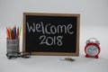 Welcome 2018 text on chalkboard with various school supplies