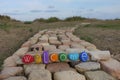 Welcome text on a wood with many colored stones over a bricks road