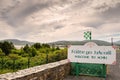 Welcome to Achill sign in Irish and English language by road. Travel and tourism information. Cloudy sky. Small county colors flag Royalty Free Stock Photo