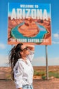 Beautiful woman on her trip to the USA on the background of Welcome to Arizona State border sign right in the Paje Royalty Free Stock Photo