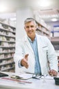 Welcome to the best pharmacy in town. Portrait of a cheerful mature male pharmacist reaching out to give a handshake